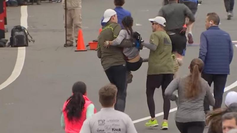In the clip, the woman is seen trying hard to keep up with other marathon participants before being helped by three men who stop mid-race for her. (Credit: YouTube)