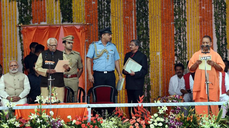 Uttar Pradesh Governor Ram Naik administers oath of office and secrecy to the new UP Chief Minister Yogi Adityanath at the swearing-in ceremony in Lucknow on Sunday. (Photo: PTI)