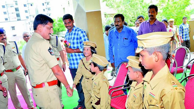 Andhra Pradesh DGP R.P. Thakur wishes the kids in the family of martyred policemen dressed in police uniform in Guntur city on Wednesday. (Photo: DC)