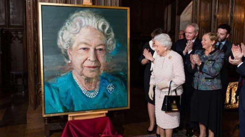 Britains Queen Elizabeth II unveils a portrait of herself by artist Colin Davidson, during a Co-operation Ireland reception at Crosby Hall in London. (Photo: AP)