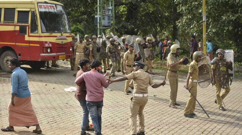 A policeman charges his baton at protestors who tried to block women of menstruating age from going to the Sabarimala temple at Nilackal, a base camp on way to the mountain shrine in Kerala. (Photo: AP)