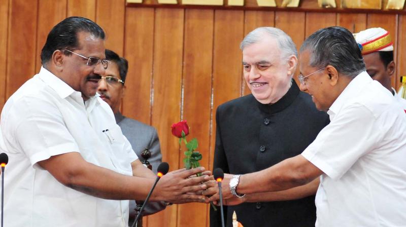 Chief minister Pinarayi Vijayan presents a rose to E.P.Jayarajan soon after the latter was  sworn in as minister by Governor P. Sathasivam at the Raj Bhavan in Thiruvananthapuram on Tuesday. (Photo: A.V.MUZAFAR)