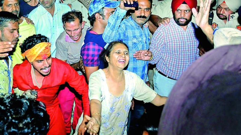 Relatives mourn near a victim at the site of a train accident at Joda Phatak in Amritsar on Friday.  (Photo:PTI)