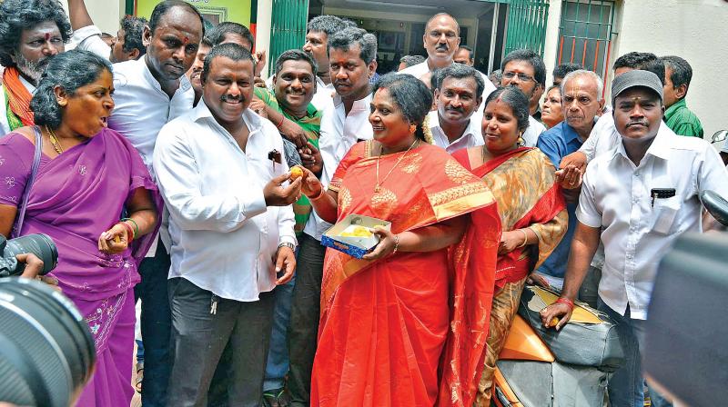 State BJP president Tamilisai Soundararajan distributes sweets at her office on Tuesday following victory in Karnataka elections (Photo: DC)