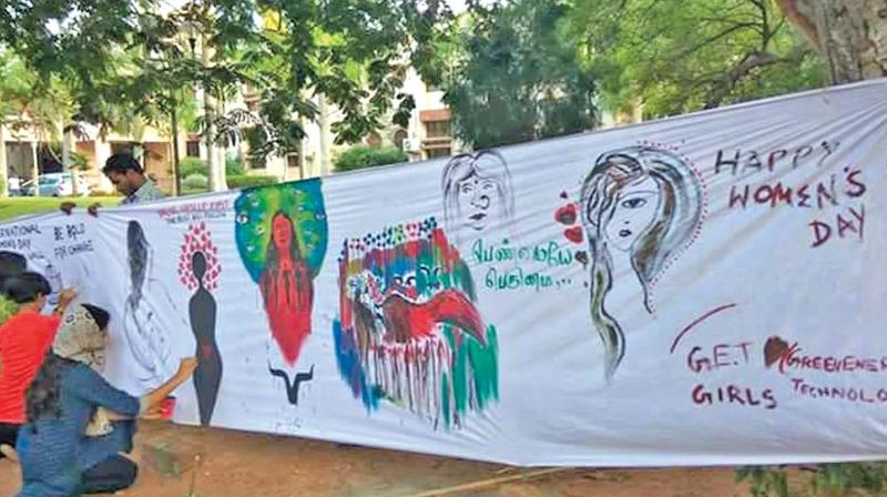 Women painting on the creative wall on Thursday. (Photo: DC)