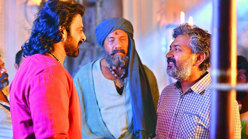 Actors Prabhas and Sathyaraj along with director S.S. Rajamouli, in discussion during the shoot of Baahubali