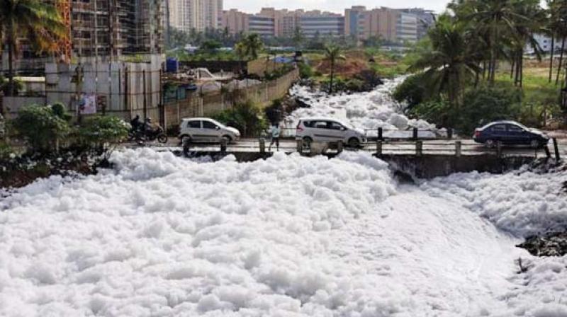 Vehicles move through the foam at Bellandur lake
