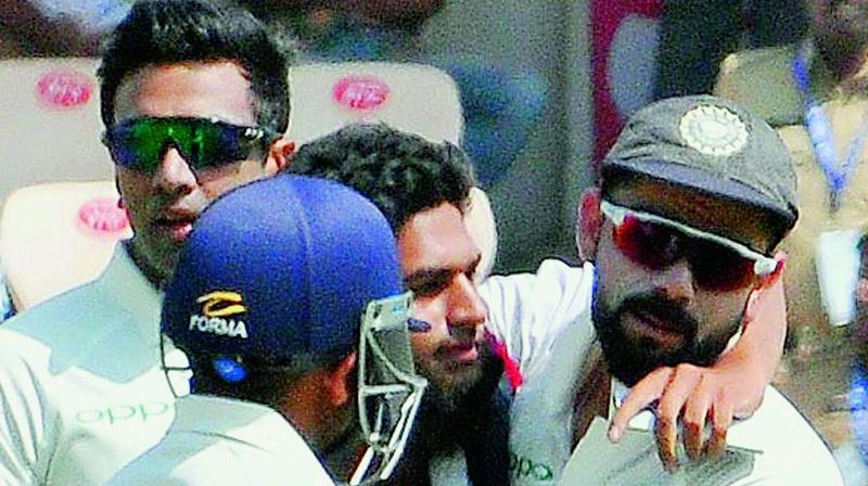 A spectator hugs Indian captain Virat Kohli after breaching security and running on to the ground during the India vs West Indies cricket Test at RGICS on Friday.	 P. Surendra