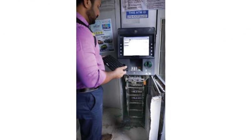 Police checks the SBI ATM that was robbed in Irumbanam  on Friday. 	DC