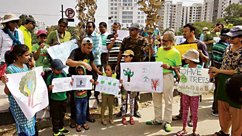 Residents of Iblur and Green Glen Layout form human chain on Outer Ring Road on Saturday to protest against chopping of 25 tress to improve visibility of a hoarding  (Image: DC)