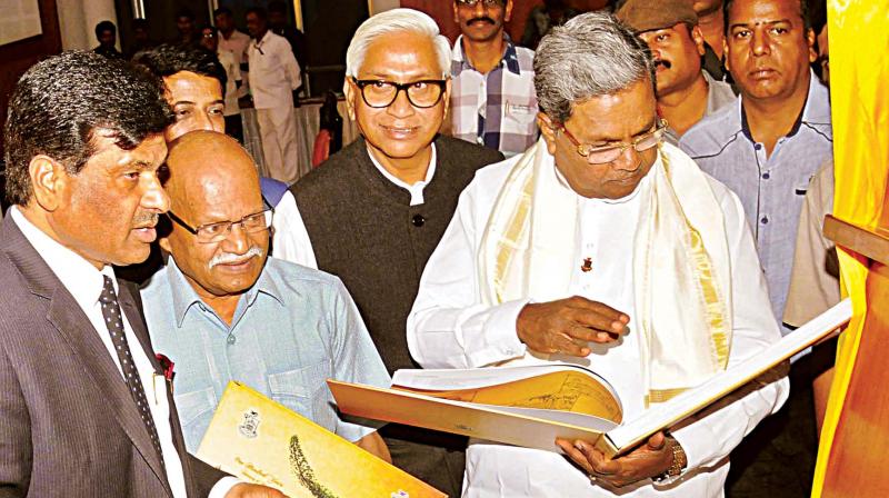 Chief Minister Siddaramaiah releases commemorative stamps to mark the centenary of University of Mysore in Mysuru on Friday.