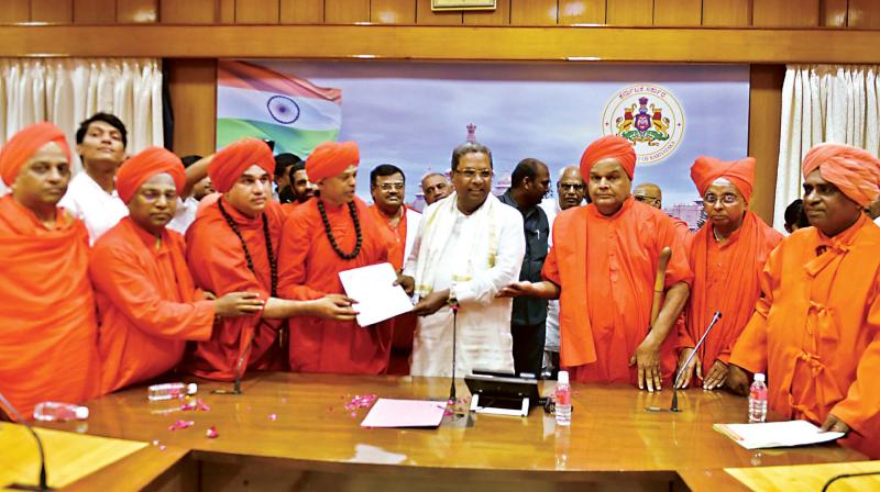 A file photo of seers of Lingayat Maths seen with Chief Minister Siddaramaiah during a meeting at Krishna CMs home office in Bengaluru on Sunday	KPN