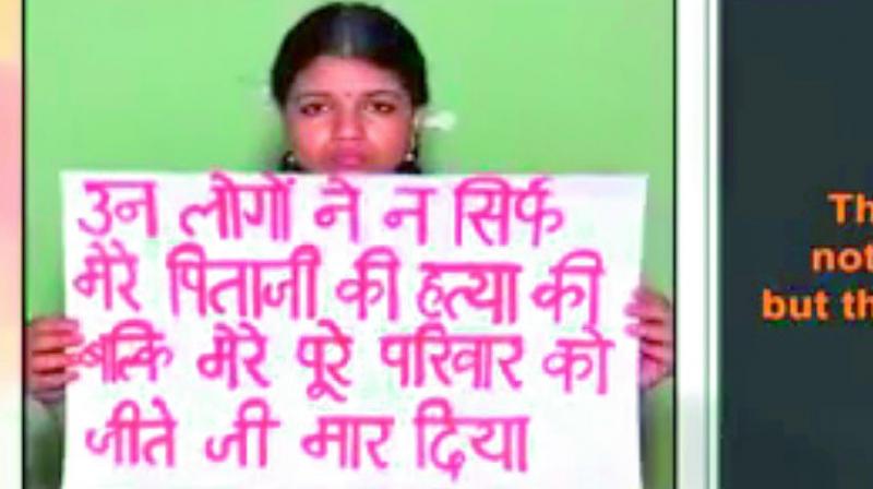 Vismaya holds a placard that reads they have murdered not just my father, but my family too in Hindi.