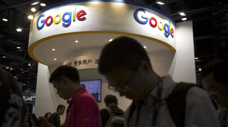Visitors use their smartphones in front of a booth for Google at the Global Mobile Internet Conference (GMIC) in Beijing. (AP Photo/Mark Schiefelbein, File)