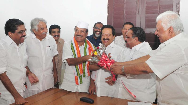 UDF convener P.P. Thankachan hands over a bouquet to IUML leader P.K. Kunhalikkutty during the first UDF meeting ever since he won the Malappuram bypoll. Former KPCC president V.M. Sudheeran, former chief minister Oommen Chandy, opposition leader Ramesh Chennithala and KPCC president M.M. Hassan look on.   (Photo: A.V. MUZAFAR)