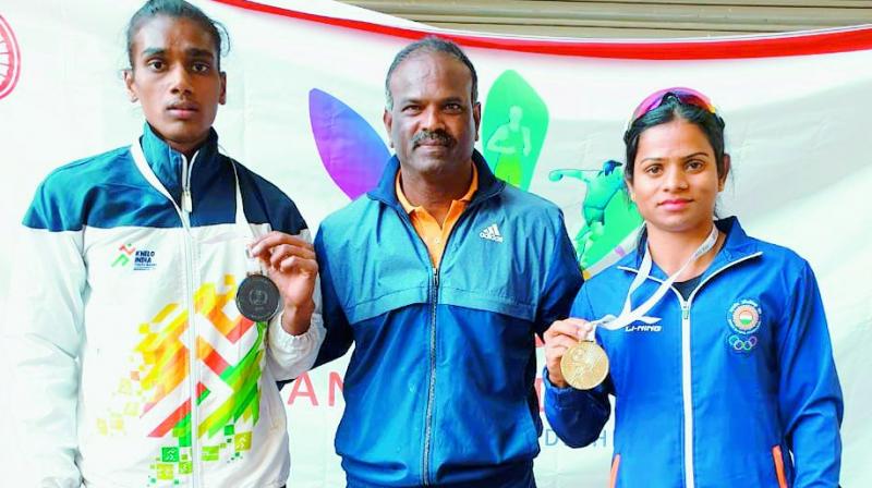 Dutee Chand poses with her gold medal alongside coach N. Ramesh and bronze medallist Supriya Maddal (left) of Andhra Pradesh in the Indian Grand Prix athletics meet in New Delhi on Wednesday.