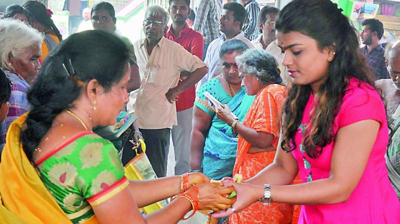 A woman gives prasadam to a girl at Mulastaneswara Swamy temple in Nellore on Monday. (Photo:  DC)