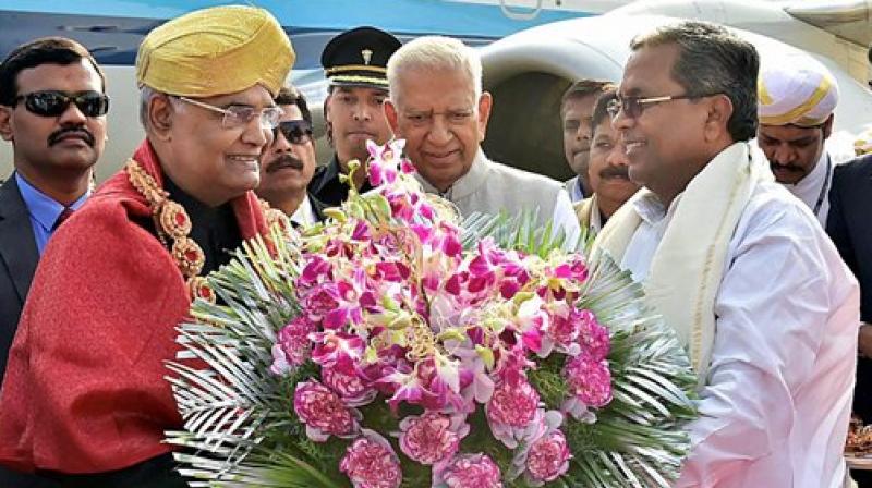 Karnataka Governor Vajubhai Vala and Chief Minister Siddharamaiah present a bouquet to President Ram Nath Kovind while receiving him on his arrival at HAL Airport in Bengaluru on Tuesday. (Photo: PTI)
