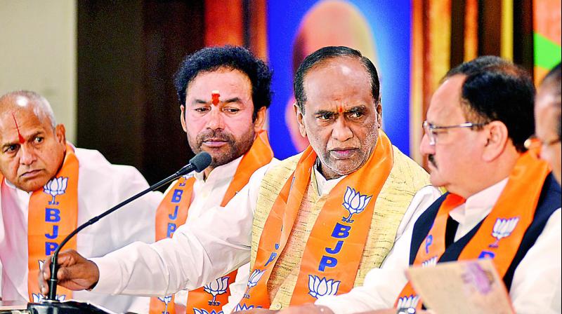 BJP state president Dr K. Laxman (centre) speaks to MLA Chinthala Ramachandra Reddy (right) at BJP State Office, Nampally. MLA G. Kishan Reddy (left) and other leaders were also present during the release of the charge sheet against TRS government. (Photo: DC)