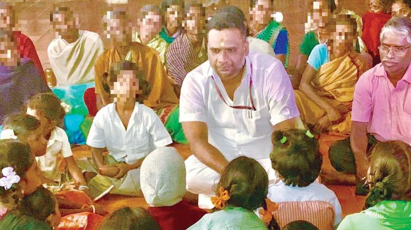 Dr R G Anand, member of the  NCPCR interacts with girl students of the government tribal residential higher secondary school near Thuraiyur in Tiruchy on Friday. (Photo: DC)