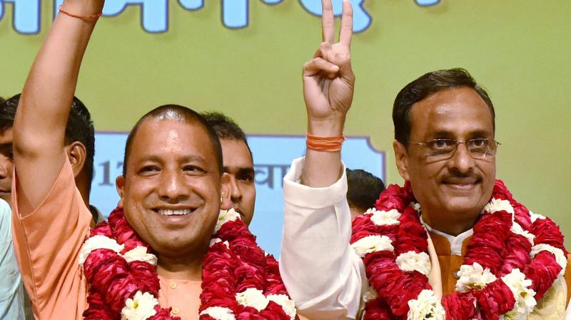 Yogi Adityanath (L) elected leader of the BJP Legislature Party (Chief Minister Uttar Pradesh) Deputy CM) Dinesh Sharma (R) in Lucknow on Saturday. (Photo: PTI)