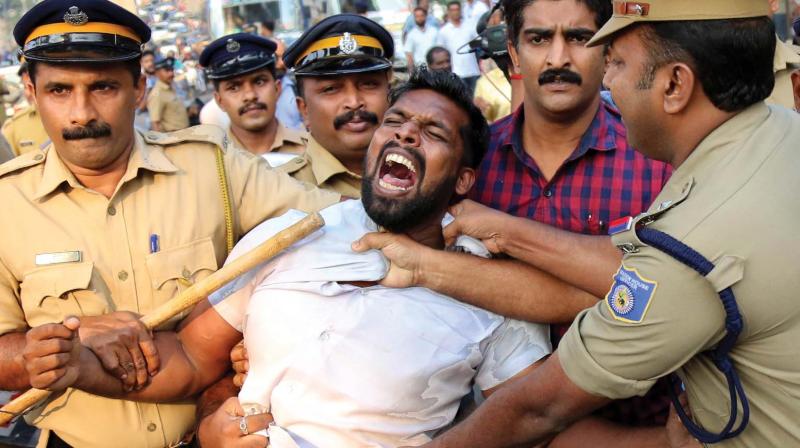 Police officials remove a Youth Congress activist trying to show a black flag to electricity minister M.M. Mani as he arrived for a function in Kochi on Saturday. Youth Congress and BJP activists held protests demanding the resignation of Mr Mani. 	(Photo: ARUNCHANDRA BOSE)