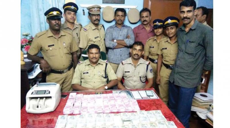 The police team with unaccounted money seized from Tirur, Melattur in Malappuram on Saturday.(Photo: DC)
