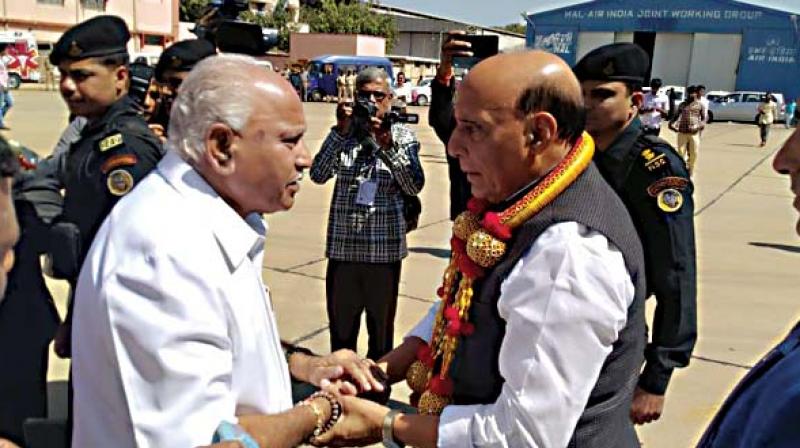 State BJP chief B.S. Yeddyurappa greets Union Home Minister Rajnath Singh on his arrival in Bengaluru on Saturday (Photo: DC)