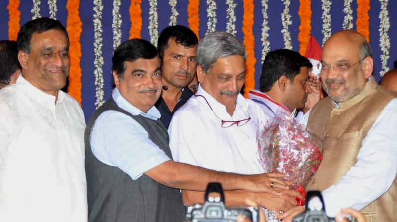 Goa Chief Minister Manohar Parrikar being greeted by BJP President Amit Shah and Union minister Nitin Gadkari after his oath at a ceremony in Panaji. (Photo: PTI)