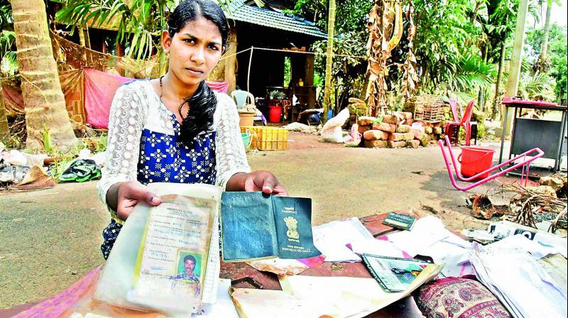 A woman shows her documents damaged due to Kerala floods at Annamanada in Thrissur on Sunday. (Photo: PTI)
