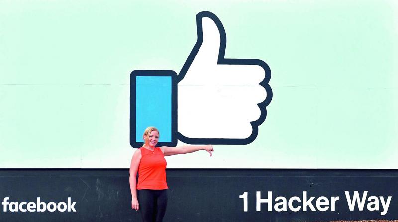 A woman makes a thumbs down sign in front of Facebooks corporate headquarters in Menlo Park, California on Thursday. (Photo: AFP)