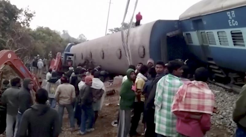 Rescuers and onlookers stand around coaches of a derailed passenger train in Kuneru, Andhra Pradesh.
