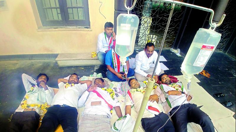 Congress workers being administrated saline after they have been on strike for three days demanding that Congress leader Rathod Ramesh should not be given Khanapur MLA ticket. (Photo: P. Surendra)