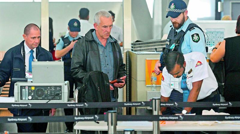 Police help screen passengers at Sydney Airport on Sunday. (Photo: AFP)