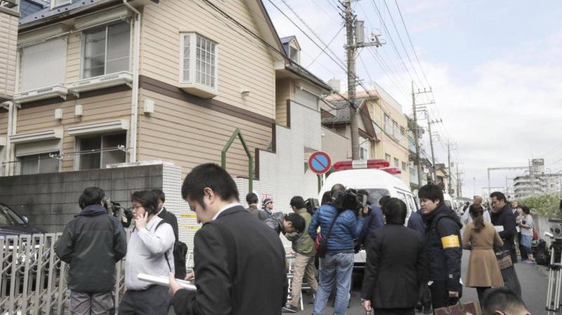 People gather in front of the apartment where police found dismembered bodies in coolers in Zama city, south west of Tokyo. (Photo: AP)
