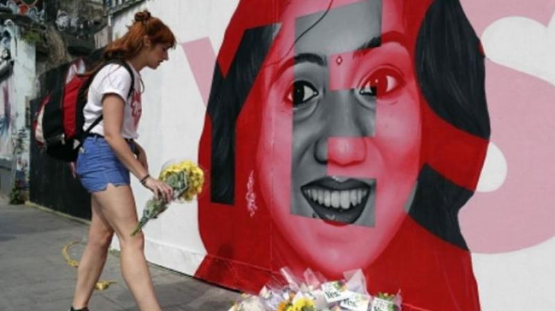 A woman places flowers by a mural showing Savita Halappanavar (Photo: AP)