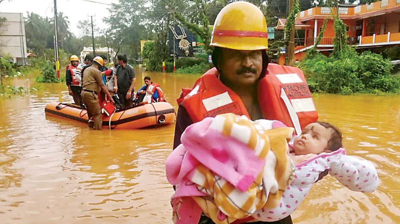 Fire service personnel shifting flood affected people at Subramanya in DK to a safe place on Thursday. (Image KPN)