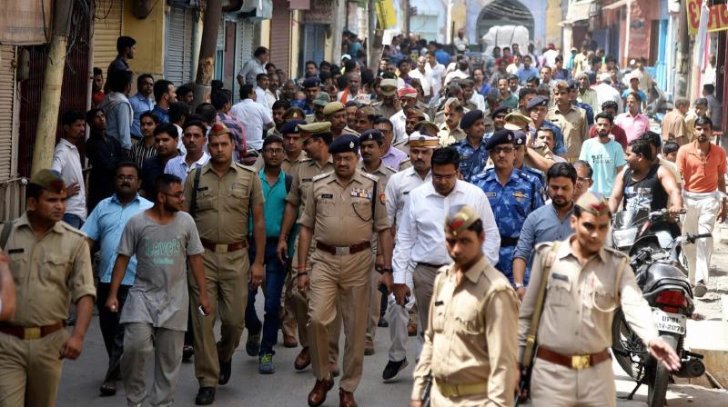 Administrative officials and security forces patrolling in old city area of Phool Chauraha in Upper Fort of Aligarh following tension. (Photo: PTI)