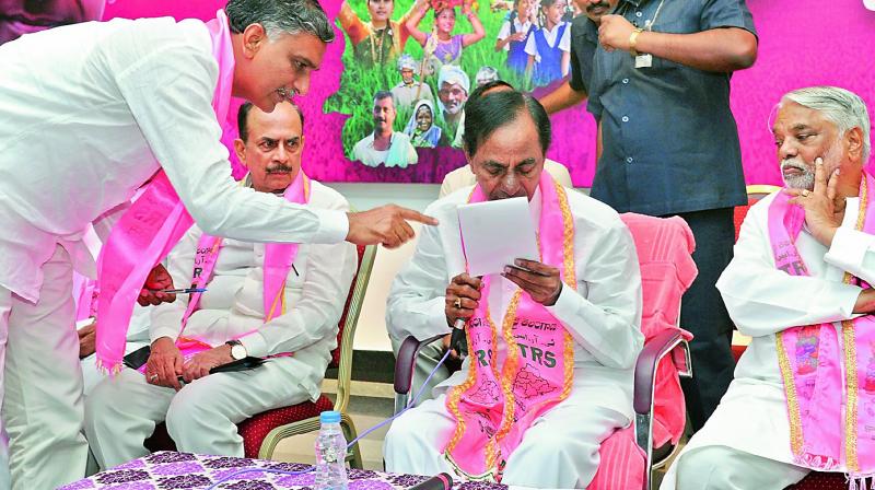 Irrigation minister T. Harish Rao explains a point to Chief Minister K. Chandrasekhar Rao while Deputy CM Mohd. Mahmood Ali and MP K. Kesava Rao look on, at a TRS party meeting in Hyderabad on Saturday. 	Photo: DC)