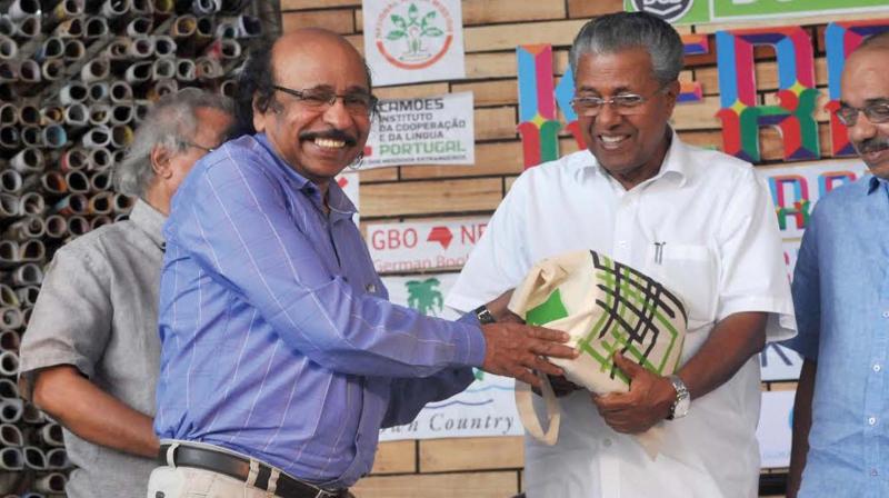 Kerala Literary Festival Director and poet K. Satchidanandan gifting books to Chief Minister Pinarayi Vijayan during the Kerala Literature Festival here at Kozhikode Beach on Saturday. (Photo: Venugopal)