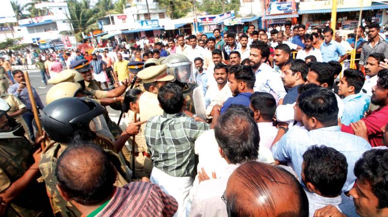 BJP workers stage a road blockade on the National Highway at Puthussery on Saturday.