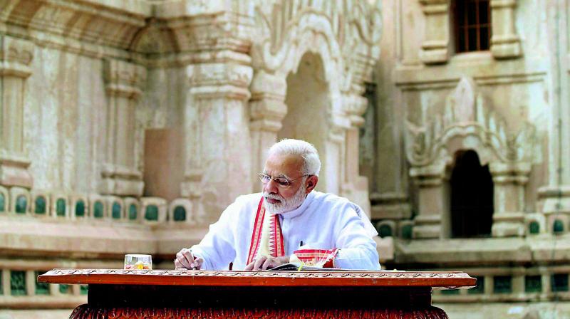 Prime Minister Narendra Modi signing the visitors book at Ananda Temple at Bagan on Wednesday. (Photo: PTI)