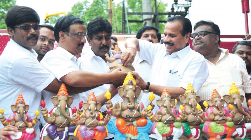 Union Minister D.V. Sadananda Gowda inserts a silver coin in an eco-friendly Ganesha idol to spread awareness on immersing idols at home, in Bengaluru on Sunday 	 DC