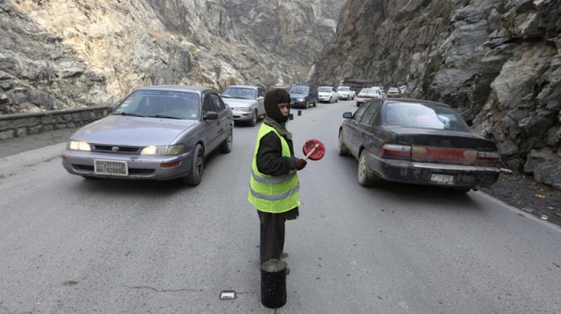 11-year-old Sedaqat signals vehicles on the Maipur Pass, along the main highway from Kabul to Pakistan, near Kabul, Afghanistan. (Photo: AP)