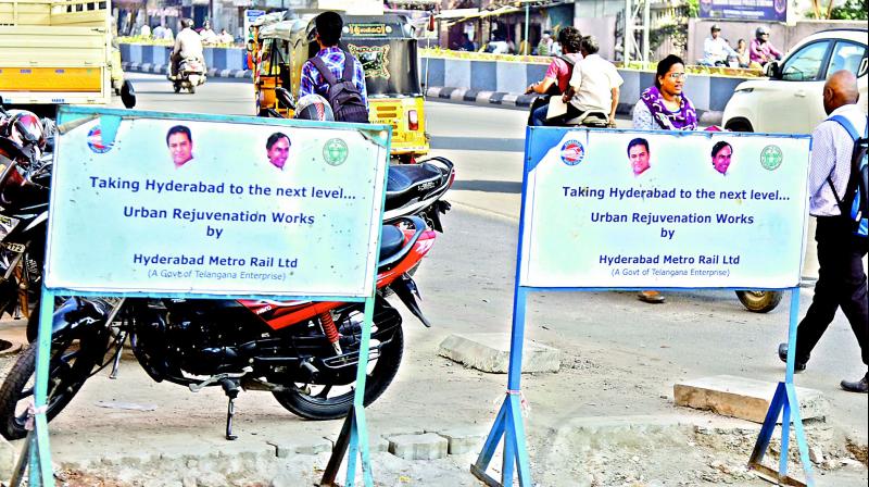 Barricades put up for the Metro Rail construction along the Dilsukhnagar to  LB Nagar stretch have images of caretaker minister K. Chandrasekhar Rao and K.T. Rama Rao.  	 S. Surender Reddy