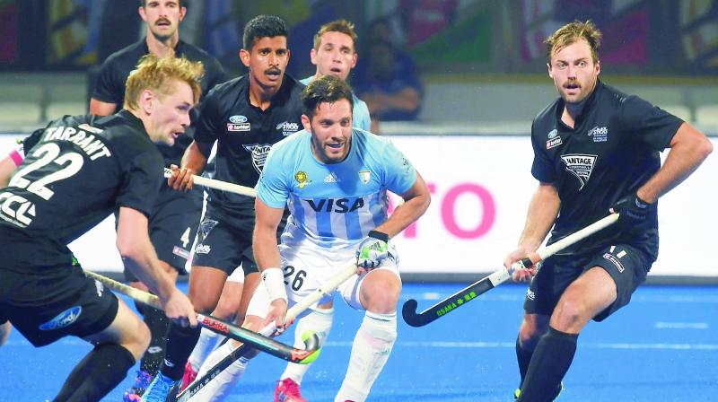 Argentinas Agustin Mazzilli (centre) goes for the ball as New Zealand players surround him during their Pool A match at the Hockey World Cup in Bhubaneswar on Monday.	(Photo:  AFP)