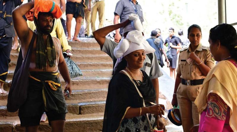 A woman devotee shows ID card to a woman cop at Pampa on Saturday.