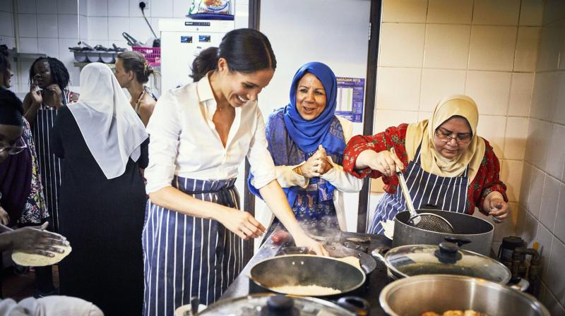 In this undated photograph issued by Kensington Palace on Monday Sept. 17, 2018, Meghan, the Duchess of Sussex cooks with women in the Hubb Community Kitchen at the Al Manaar Muslim Cultural Heritage Centre in London.(Photo: AP)