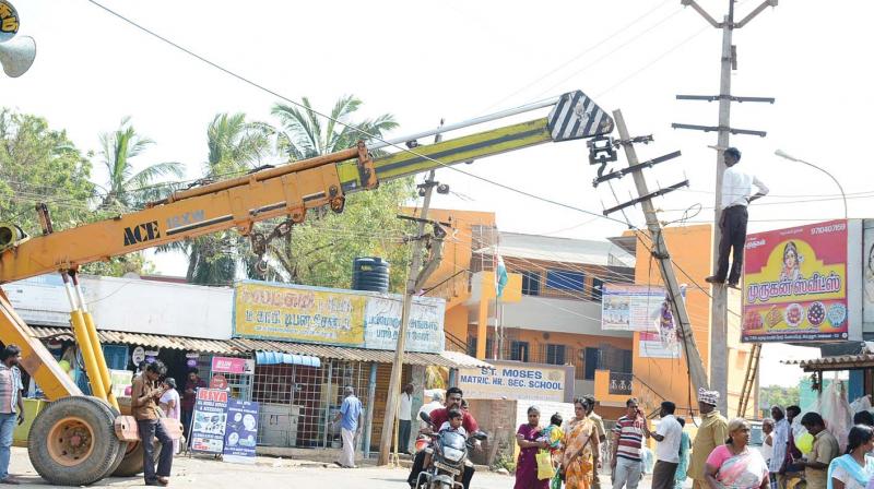 Tamil Nadu electricity board workers install a new electrical post at Karuku on Monday (Photo: DC)