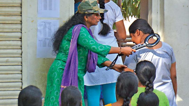 A woman official screens the girl candidates with metal detector at a Neet exam centre in Chennai.